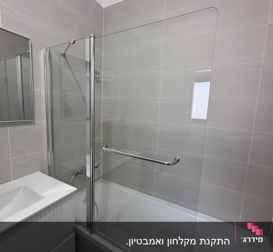 מקלחת עם אמבטיה ודלת זכוכית שקופה